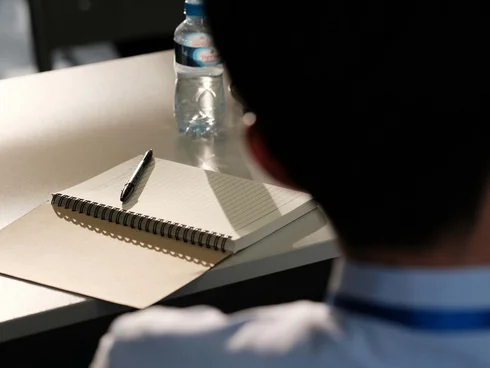 Ihr Hotel im Dahner Felsenland: Pfalzblick Wald Spa Resort Rückansicht einer Person vor einem Tisch mit Notizbuch, Stift und Wasserflasche