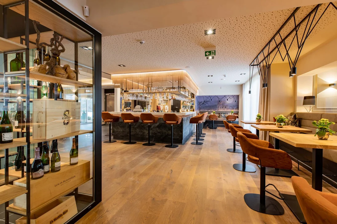 Ihr Hotel im Dahner Felsenland: Pfalzblick Wald Spa Resort Moderner Hotelbarbereich mit Holzfußboden und orangefarbenen Barhockern