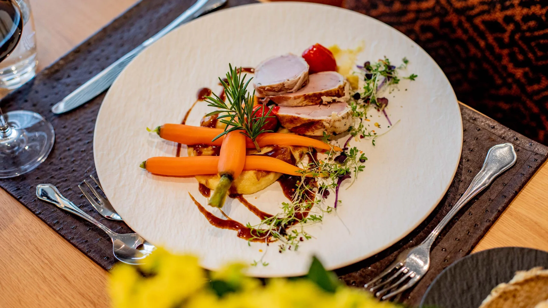 Ihr Hotel im Dahner Felsenland: Pfalzblick Wald Spa Resort Gourmetgericht mit Fleisch, Karotten, Kräutern und Sauce auf weißem Teller