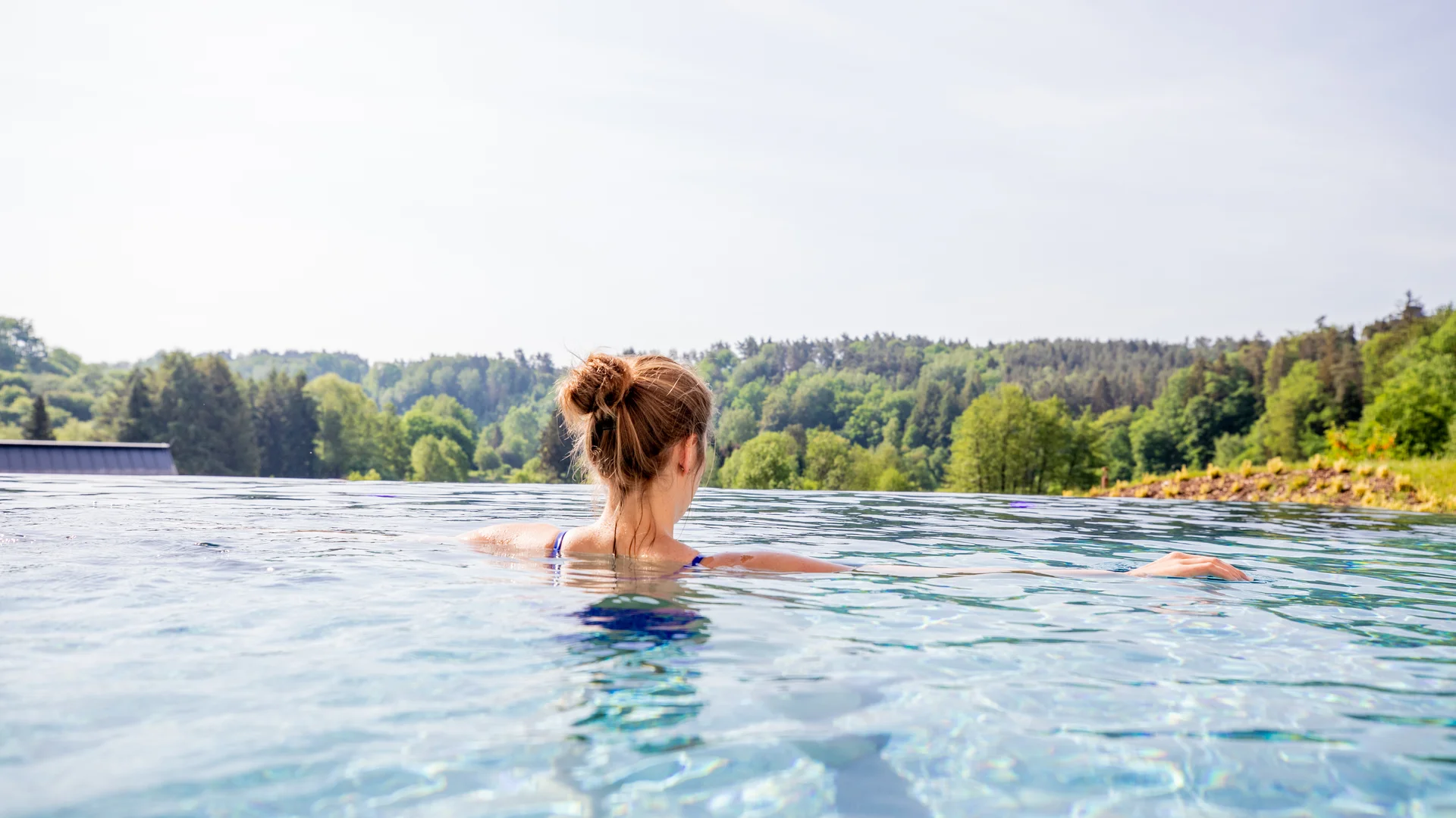Ihr Hotel im Dahner Felsenland: Pfalzblick Wald Spa Resort Frau entspannt im Infinity-Pool mit Blick auf einen Wald