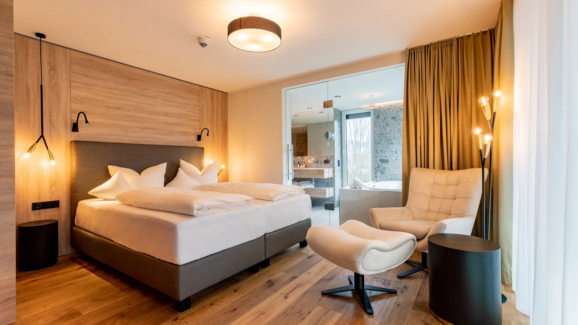 Ihr Hotel im Dahner Felsenland: Pfalzblick Wald Spa Resort Modernes Hotelzimmer mit Doppelbett, Sessel und angrenzendem Bad