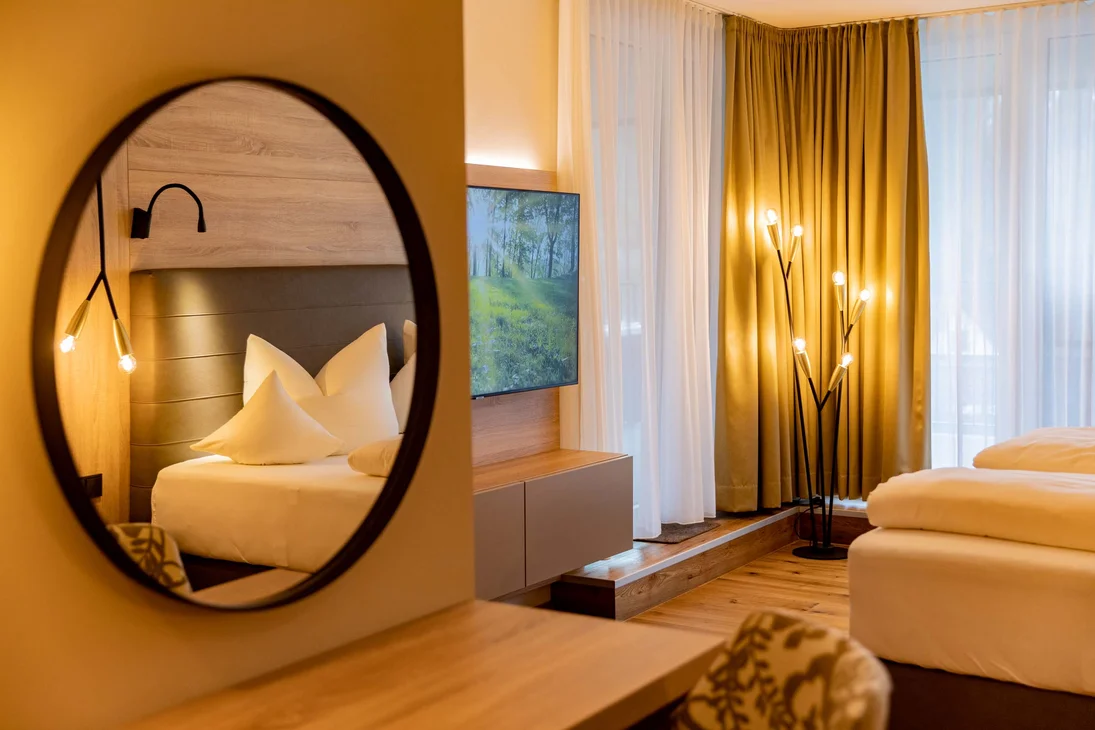 Ihr Hotel im Dahner Felsenland: Pfalzblick Wald Spa Resort Modernes Hotelzimmer mit Badspiegel, gemütlichem Bett und warmem Licht