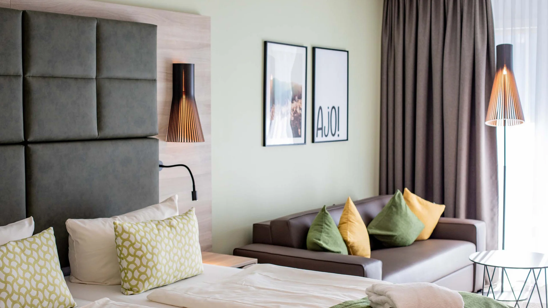 Ihr Hotel im Dahner Felsenland: Pfalzblick Wald Spa Resort Modernes Hotelzimmer mit Bett, Sofa und dekorativen Kissen