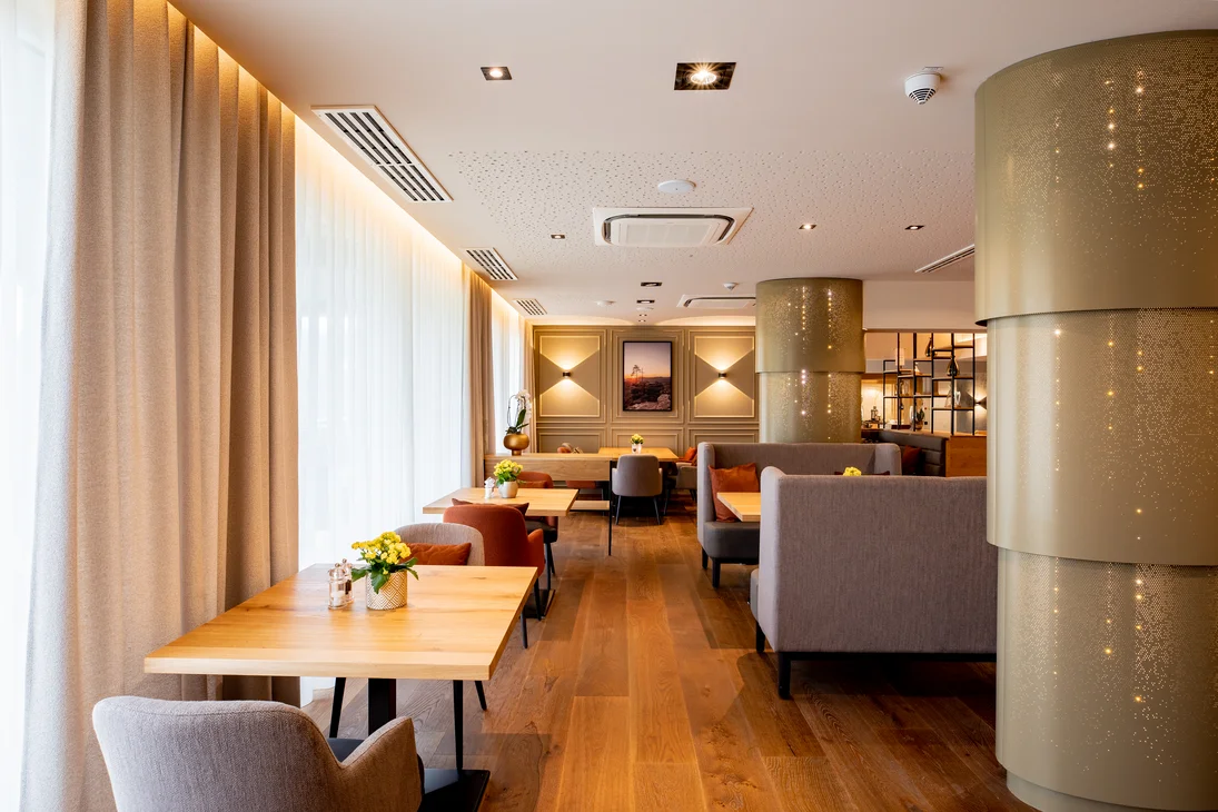 Ihr Hotel im Dahner Felsenland: Pfalzblick Wald Spa Resort Modernes Café mit Holztischen, bequemen Stühlen und warmem Licht